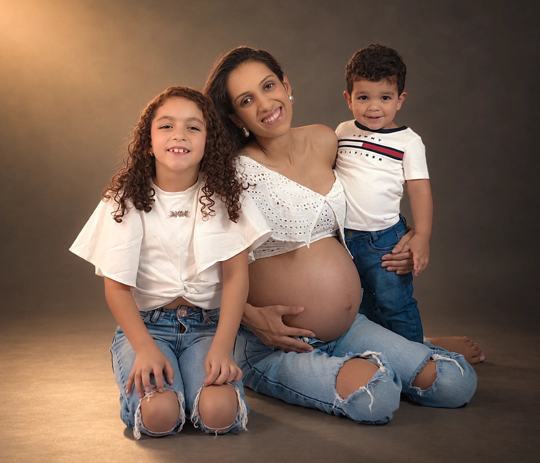 Gestante com os filhos em retrato de família